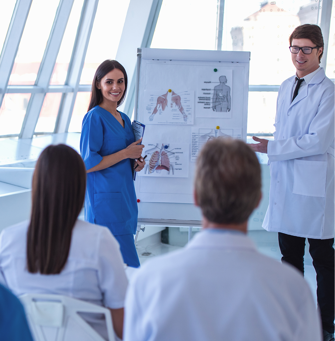 Sesión de formación sanitaria ante un rotafolio con láminas de anatomía